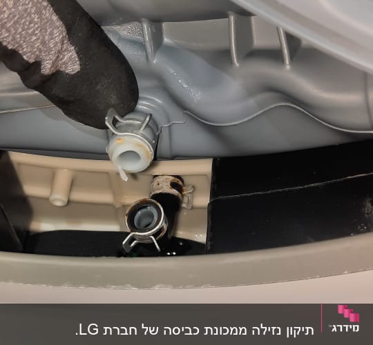 חלקים פנימיים של מכונת כביסה עם צינור וחיבורים